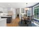 Bright, modern kitchen features stainless appliances, center island, and adjacent breakfast nook at 5117 Dove Forest Ln, Apex, NC 27539