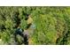 An aerial view showcasing a log cabin style home surrounded by lush, mature trees and a long private driveway at 515 Tramway West Rd, Sanford, NC 27330