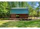 Log cabin style guest house features a green metal roof, lovely deck, and peaceful wooded surroundings at 515 Tramway West Rd, Sanford, NC 27330