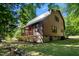 Charming cabin with a metal roof and porch, nestled in a serene wooded setting at 515 Tramway West Rd, Sanford, NC 27330