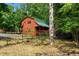 Charming log cabin with a green metal roof surrounded by lush greenery and trees at 515 Tramway West Rd, Sanford, NC 27330