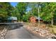 Charming log cabin with a green metal roof surrounded by lush greenery and trees at 515 Tramway West Rd, Sanford, NC 27330