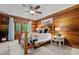 Cozy bedroom with wood walls, ceiling fan, and plenty of natural light at 515 Tramway West Rd, Sanford, NC 27330