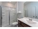 Clean, well-lit bathroom features a glass-enclosed shower, toilet, and vanity with a large mirror at 5200 Beckom St, Raleigh, NC 27616