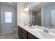 Modern bathroom with double sinks, white countertops, framed mirror, and a walk-in tiled shower at 5200 Beckom St, Raleigh, NC 27616