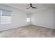 A bedroom with neutral carpet, tray ceiling, ceiling fan, and natural light from two windows at 5200 Beckom St, Raleigh, NC 27616