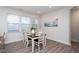 Bright dining room features a dining table set for four near large windows and an art piece at 5200 Beckom St, Raleigh, NC 27616