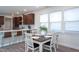 Sunlit dining area with a dining table set for four beside the kitchen, light from large windows at 5200 Beckom St, Raleigh, NC 27616