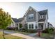 Charming two-story home boasts stone accents, gray siding, a manicured lawn, and vibrant flowerbeds at 5200 Beckom St, Raleigh, NC 27616