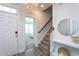 Welcoming foyer features hardwood floors, staircase with wooden railing and views into another room at 5200 Beckom St, Raleigh, NC 27616