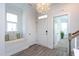 Bright foyer features beautiful hardwood floors, a window seat, and an elegant chandelier at 5200 Beckom St, Raleigh, NC 27616
