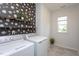 Well-lit laundry room featuring modern appliances and stylish decorative wallpaper at 5200 Beckom St, Raleigh, NC 27616