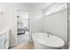 Bright bathroom featuring soaking tub with view into the main bedroom at 521 Marion Hills Way, Knightdale, NC 27545