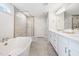 Bright bathroom featuring double vanity, soaking tub, and glass enclosed shower at 521 Marion Hills Way, Knightdale, NC 27545