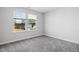 Neutral bedroom featuring carpeted floors, two large windows, and painted walls at 521 Marion Hills Way, Knightdale, NC 27545
