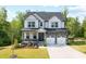 Charming two-story home with stone accents, a covered porch, and a well-manicured lawn at 521 Marion Hills Way, Knightdale, NC 27545