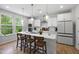Modern kitchen with white cabinets, quartz countertops, stainless steel appliances, and pendant lighting at 521 Marion Hills Way, Knightdale, NC 27545