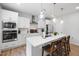 Bright kitchen featuring stainless steel appliances, white cabinets, and a spacious island with seating at 521 Marion Hills Way, Knightdale, NC 27545