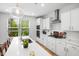 Stylish kitchen with white cabinets, quartz countertops, and stainless steel appliances under pendant lights at 521 Marion Hills Way, Knightdale, NC 27545