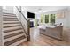 Open living room with a fireplace, large windows, hardwood floors, and a comfortable sofa at 521 Marion Hills Way, Knightdale, NC 27545