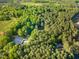 An aerial view of the sprawling property shows the house, horse riding facilities and surrounding forest at 54 Malcolm Neal Path, Louisburg, NC 27549
