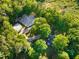 Overhead shot of a property showcasing a barn, horse riding area, house, and rich tree cover at 54 Malcolm Neal Path, Louisburg, NC 27549