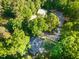 Aerial view showcasing a home, barn, and riding arena on a wooded lot at 54 Malcolm Neal Path, Louisburg, NC 27549