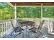 Relaxing back porch with black metal table and chairs overlooking a serene wooded area at 54 Malcolm Neal Path, Louisburg, NC 27549