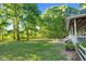 Expansive backyard with lush lawn, mature trees, and patio area with chairs at 54 Malcolm Neal Path, Louisburg, NC 27549