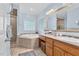 Bright bathroom with double vanity, framed mirrors, glass shower, and soaking tub at 54 Malcolm Neal Path, Louisburg, NC 27549
