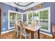 Bright dining room featuring a rustic table, large windows, and modern chandelier at 54 Malcolm Neal Path, Louisburg, NC 27549