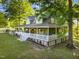 Aerial shot of a charming home featuring a spacious wrap-around porch and lush greenery at 54 Malcolm Neal Path, Louisburg, NC 27549