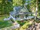 Aerial view of a home with a wrap-around porch, patio, fenced yard, and mature trees at 54 Malcolm Neal Path, Louisburg, NC 27549