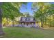 Charming two-story house with a wide porch, surrounded by lush trees at 54 Malcolm Neal Path, Louisburg, NC 27549