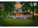 Charming home with a wraparound porch, white railings, lush lawn and mature trees create a serene setting at 54 Malcolm Neal Path, Louisburg, NC 27549