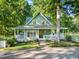Inviting home with a large wrap-around porch, stone pathway, and well-maintained landscaping at 54 Malcolm Neal Path, Louisburg, NC 27549