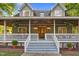 Inviting front porch with seating, decorative plants, and detailed woodwork at 54 Malcolm Neal Path, Louisburg, NC 27549