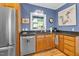 Traditional kitchen features wood cabinets, stainless appliances, and blue accent wall at 54 Malcolm Neal Path, Louisburg, NC 27549
