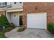 Inviting front entrance of townhome with well-maintained landscaping and attached garage at 604 Oakfield Trl, Mebane, NC 27302