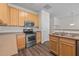 A kitchen showcasing stainless steel appliances, light wood cabinetry, and dark wood-look flooring at 604 Oakfield Trl, Mebane, NC 27302