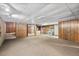 Spacious carpeted basement with wood paneled walls and drop ceiling, offering ample potential at 620 Mcghees Mill Rd, Roxboro, NC 27574