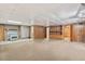 Basement showcasing a brick fireplace, with built-in shelving and wood paneled walls at 620 Mcghees Mill Rd, Roxboro, NC 27574