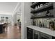 Stylish home bar area with sleek shelving, mirrored backsplash, and convenient beverage storage at 6208 Old Miravalle Ct, Raleigh, NC 27614