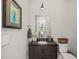 Stylish powder room features a dark vanity with vessel sink, modern fixtures, and decorative mirror at 6208 Old Miravalle Ct, Raleigh, NC 27614