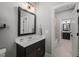Well-lit bathroom with a dark vanity, sleek mirror, and combination shower/tub at 6208 Old Miravalle Ct, Raleigh, NC 27614