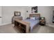 A modern bedroom featuring a bed with bookshelf, astronaut picture, and neutral carpet at 6208 Old Miravalle Ct, Raleigh, NC 27614