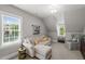 Cozy bonus room with a comfortable sectional sofa, accent chair, and abundant natural light at 6208 Old Miravalle Ct, Raleigh, NC 27614
