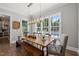 Inviting dining room with a rustic table, bench, and large windows offering beautiful backyard views and natural light at 6208 Old Miravalle Ct, Raleigh, NC 27614