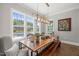 Bright dining room with large windows, stylish lighting, and a rustic wood table with bench seating at 6208 Old Miravalle Ct, Raleigh, NC 27614