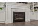 Elegant white fireplace with marble surround and built-in shelving adds charm to the living space at 6208 Old Miravalle Ct, Raleigh, NC 27614